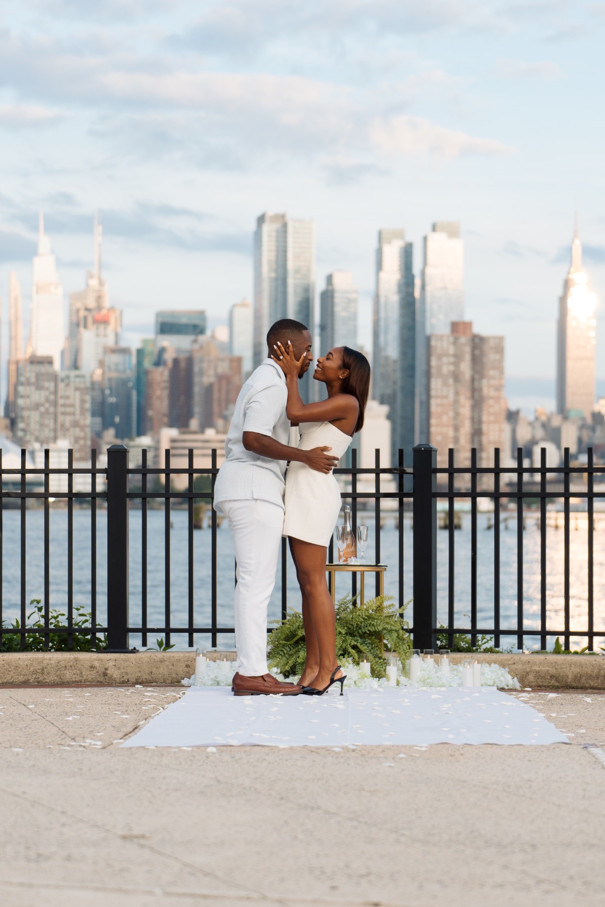 Newly engaged couple embracing before the NYC skyline