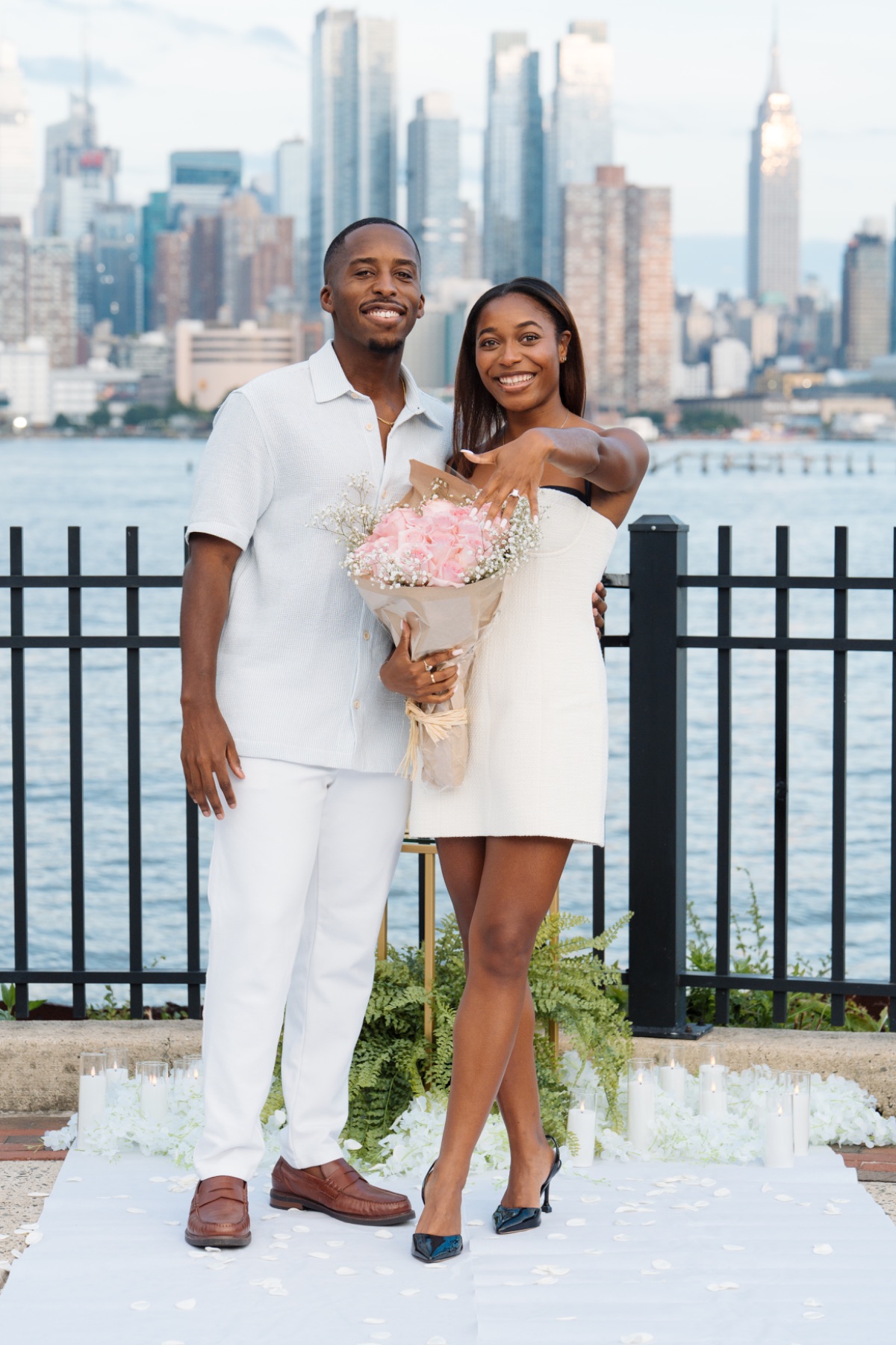 Engaged couple showing the ring with roses